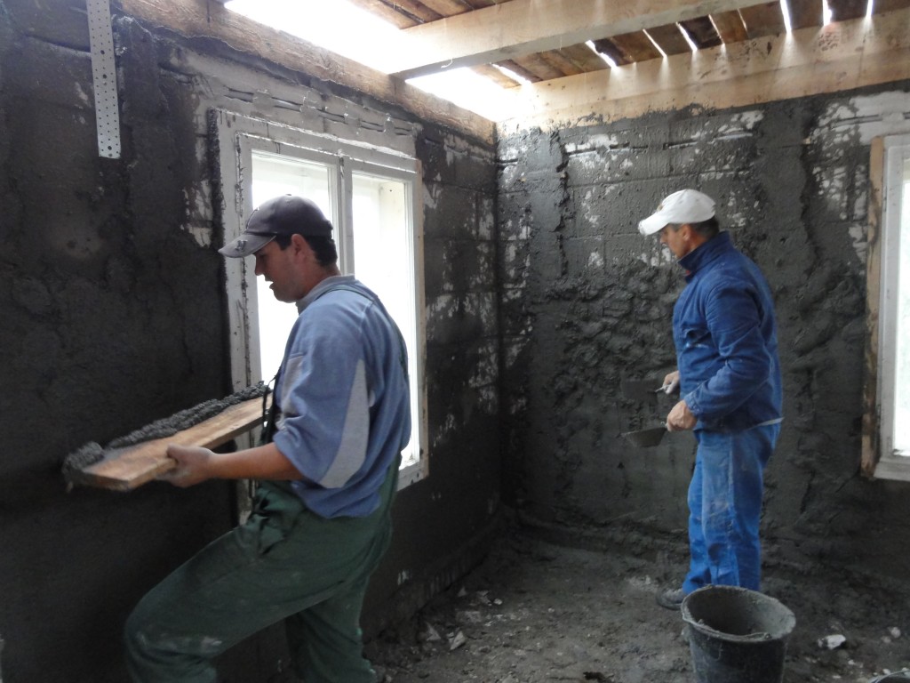 Olivio and Augustine plastering the walls
