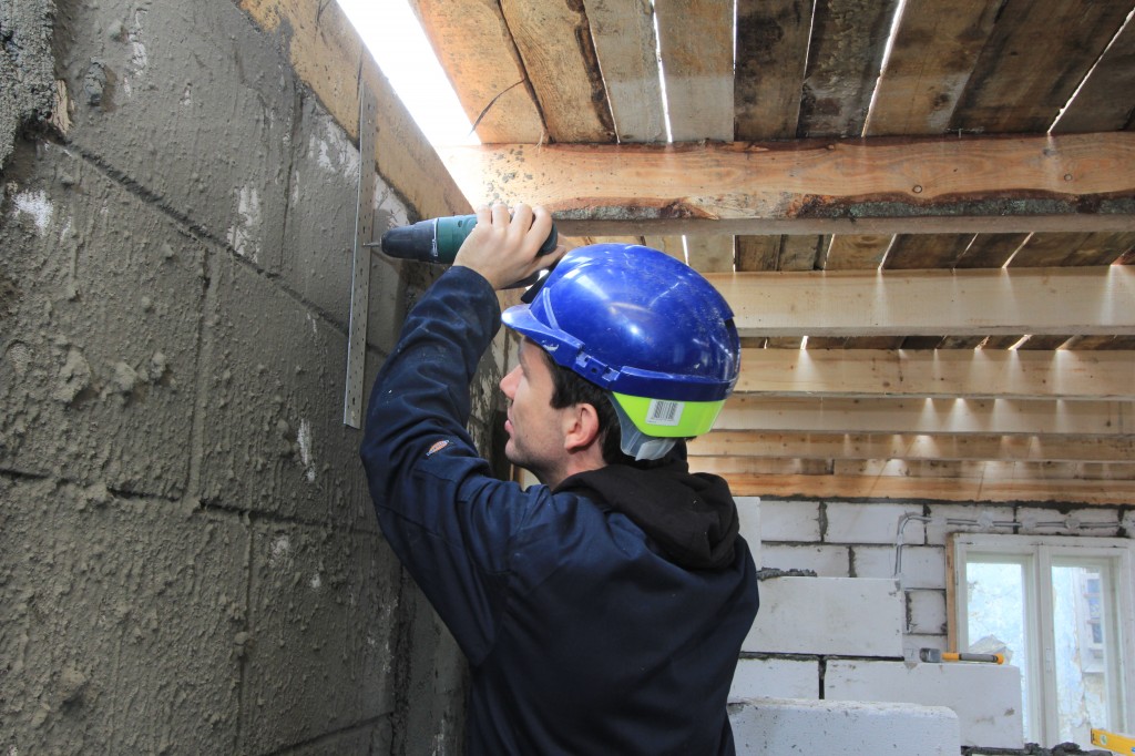 Me securing the wooden frame for the roof to the walls