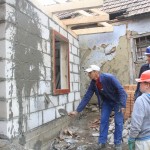 Augustine demonstrating the art of plastering to Archie and I